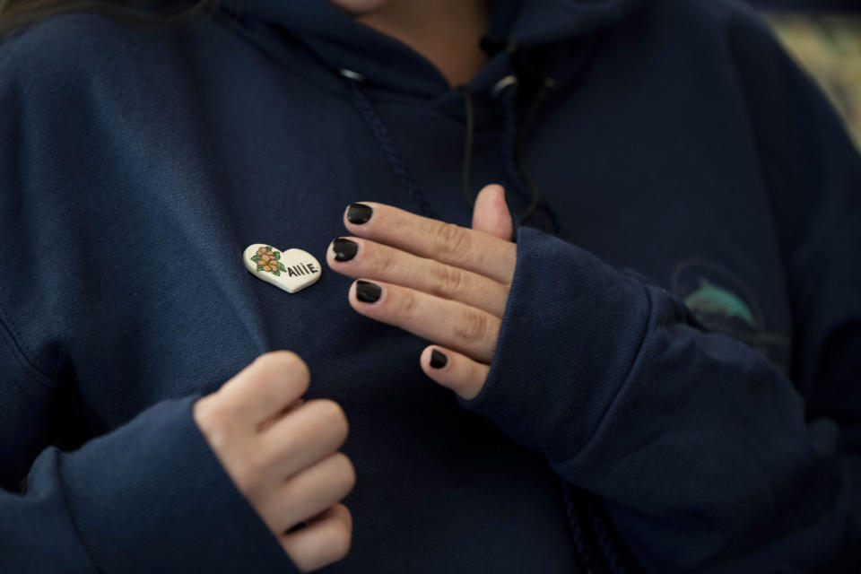 Olivia Kurtz wears a pin in memory of her sister Allie, who lost her life on the dive boat Conception, during at interview with The Associated Press on Wednesday, Sept. 4, 2019, in Santa Barbara, Calif. A fire raged through the boat carrying recreational scuba divers anchored near an island off the Southern California Coast Monday, leaving multiple people dead. (AP Photo/Christian Monterrosa)