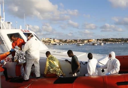Migrants who survived a shipwreck arrive at the Lampedusa harbour February 11, 2015. REUTERS/Antonio Parrinello