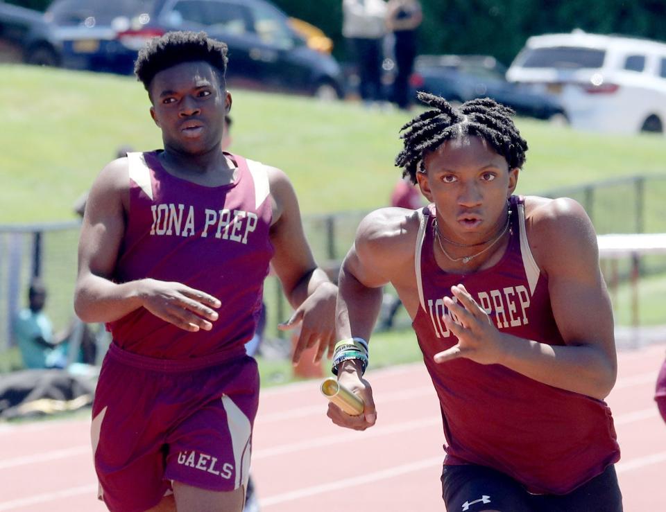 Marcellus Harris of Iona Prep takes the baton from Jordan Hargraves during the sprint medley relay at the Eastern States track and field meet at Iona Prep in New Rochelle June 5, 2022.