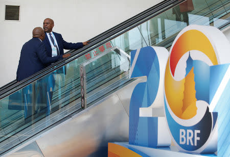 Delegates on an escalator ride past a Belt and Road Forum (BRF) logo at the China National Convention Center, in Beijing, China, April 25, 2019. REUTERS/Jason Lee