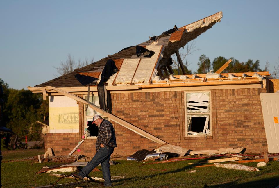 A man searches for his glasses he dropped the night before in front of his daughter's home destroyed by a tornado in Powderly, Texas, Saturday, Nov. 5, 2022.