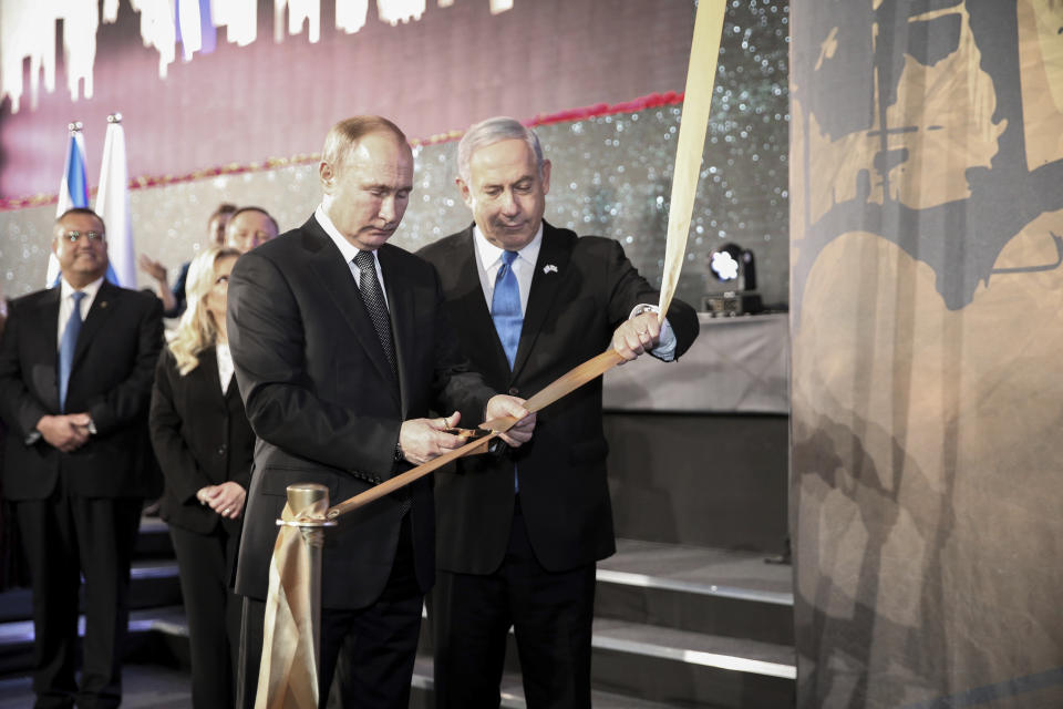 Russian President Vladimir Putin, left, cuts a ribbon with Israeli Prime Minister Benjamin Netanyahu during the dedication of a monument honoring the veterans and victims of the siege of Leningrad in Jerusalem, Thursday, Jan. 23, 2020. Putin, French President Emmanuel Macron, Britain’s Prince Charles, Vice President Mike Pence and the presidents of Germany, Italy and Austria were among the more than 40 dignitaries attending the World Holocaust Forum, which coincides with the 75th anniversary of the liberation of the Auschwitz death camp. (Amit Shabi/Pool Photo via AP)