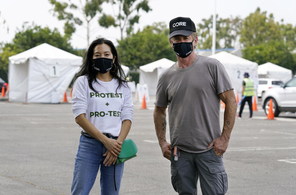 Ann Lee, left, CEO of Community Organized Relief Effort (CORE), and founder Sean Penn pose together at a CORE coronavirus testing site at Crenshaw Christian Center, Friday, Aug. 21, 2020, in Los Angeles. Penn says his organization CORE has made some strides against the coronavirus and he's keeping its mission going by expanding testing and other relief services. (AP Photo/Chris Pizzello)