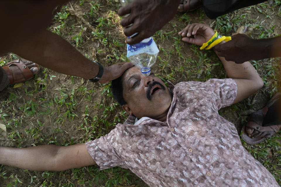 A supporter of Sri Lanka's main opposition injured in clashes with police is attended to by others during a protest rally against high taxes and increases in electricity and fuel charges, in Colombo, Sri Lanka, Tuesday, Jan. 30, 2024. (AP Photo/Eranga Jayawardena)