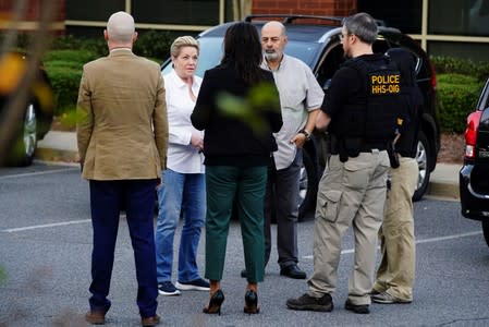 Federal agents speak with Victoria Nemerson, General Counsel for Alpha Medical Consulting, and an unidentified man, prior to executing a search warrant on multiple business at an office park in Lawrenceville