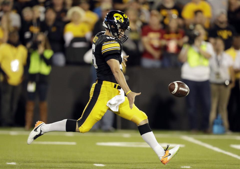 Iowa punter Ron Coluzzi fell victim to the turf monster. (AP Photo/Charlie Neibergall)