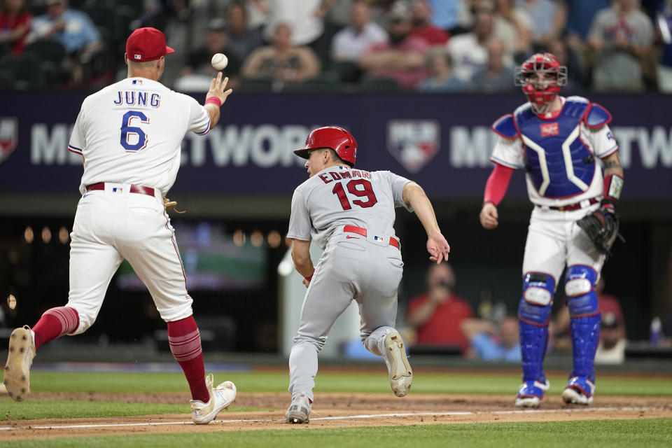 Texas Rangers' Josh Jung (6) tosses the ball to catcher Jonah Heim, right, as St. Louis Cardinals' Tommy Edman (19) attempts to score on a Nolan Arenado double in the eighth inning of a baseball game, Monday, June 5, 2023, in Arlington, Texas. Edman was out on the play. (AP Photo/Tony Gutierrez)