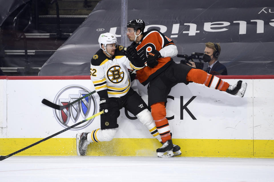 Boston Bruins' Sean Kuraly, left, and Philadelphia Flyers' Justin Braun collide during the second period of an NHL hockey game, Saturday, April 10, 2021, in Philadelphia. (AP Photo/Derik Hamilton)