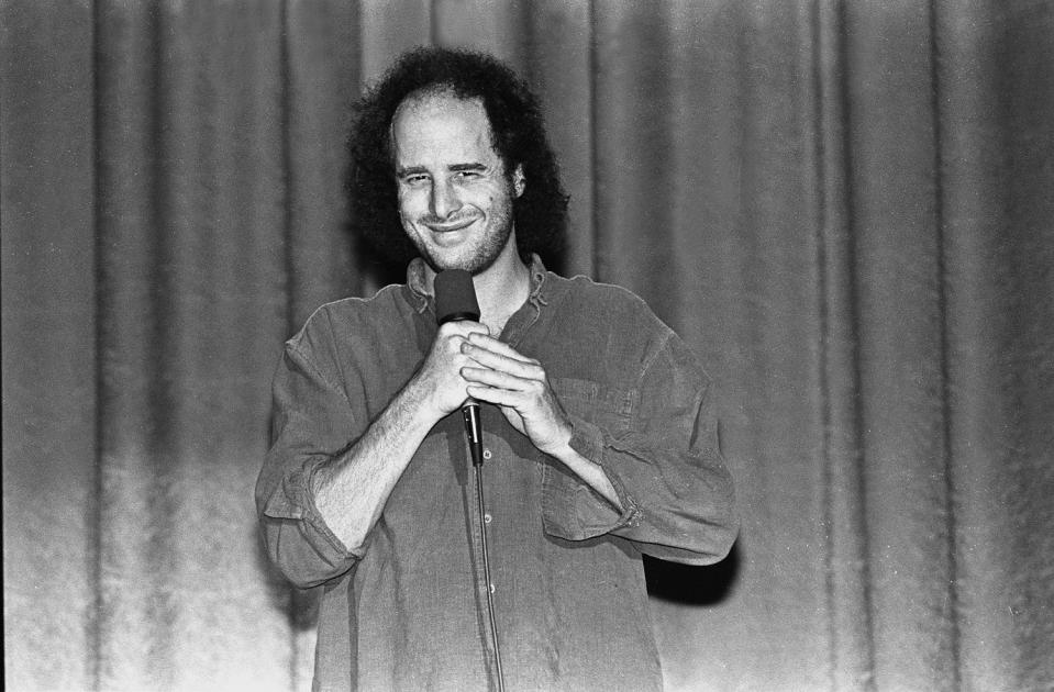 Comedian, actor and writer Steven Wright is shown performing on stage during a 