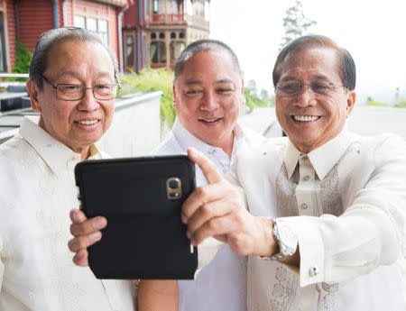 FILE PHOTO: Exiled founder of the Communist Party of the Philippines Jose Maria Sison (L), Philippines government official Joey Fornier and Philippines' presidential peace adviser Jesus Dureza (R) take a selfie photo during peace talks between the Philippine government and the National Democratic Front of the Philippines (NDFP) in Oslo, Norway August 22, 2016. Berit Roald/NTB Scanpix/ via REUTERS