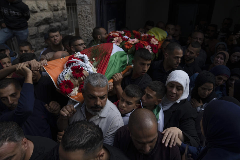 Mourners carry the body of Mohammed Fadi Nuri, 16, during his funeral, in the West Bank city of Ramallah, Thursday, Oct. 20, 2022. Nuri succumbed to his wounds sustained during clashes with Israeli troops late last month, Palestinian health officials said. Meanwhile, the Palestinians launched a general strike throughout the West Bank and east Jerusalem in response to the death of a suspected Palestinian attacker. (AP Photo/Nasser Nasser)