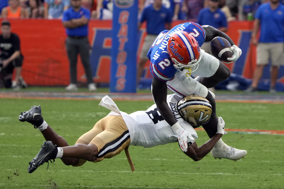 Vanderbilt cornerback Tyson Russell, left, tackles Florida running back Montrell Johnson Jr. (2) during the first half of an NCAA college football game, Saturday, Oct. 7, 2023, in Gainesville, Fla. (AP Photo/John Raoux)