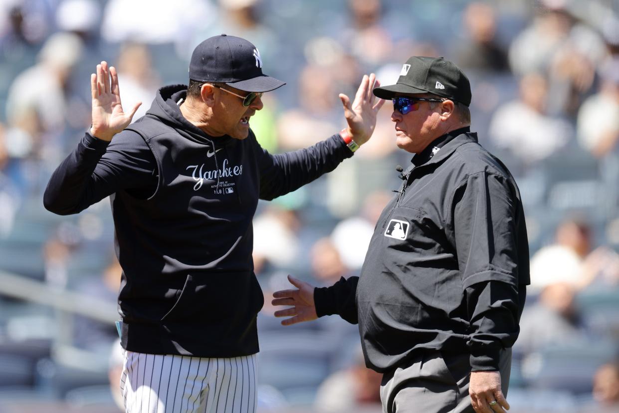 New York Yankees manager Aaron Boone (left) argues with third base umpire Marvin Hudson in the first inning during the game against the Oakland Athletics at Yankee Stadium.