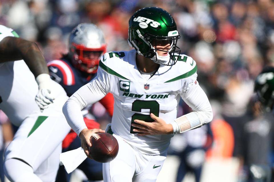 New York Jets quarterback Zach Wilson (2) looks to hand off the ball during the first half of a game against the New England Patriots at Gillette Stadium.