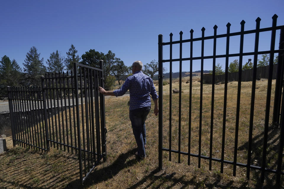 Will Abrams walks on the lot of his family home that was destroyed by wildfires in 2017 while interviewed in Santa Rosa, Calif., Thursday, June 24, 2021. Pacific Gas & Electric's CEO is pledging that the future will get “easier” and “brighter.” But those words are ringing hollow one year after PG&E emerged from a complex bankruptcy triggered by a succession of harrowing wildfires ignited by its long-neglected electrical grid. (AP Photo/Jeff Chiu)