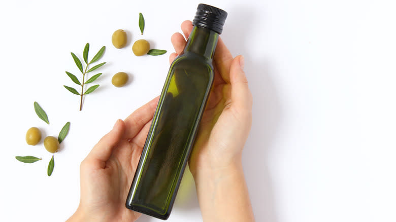 Holding bottle of olive oil