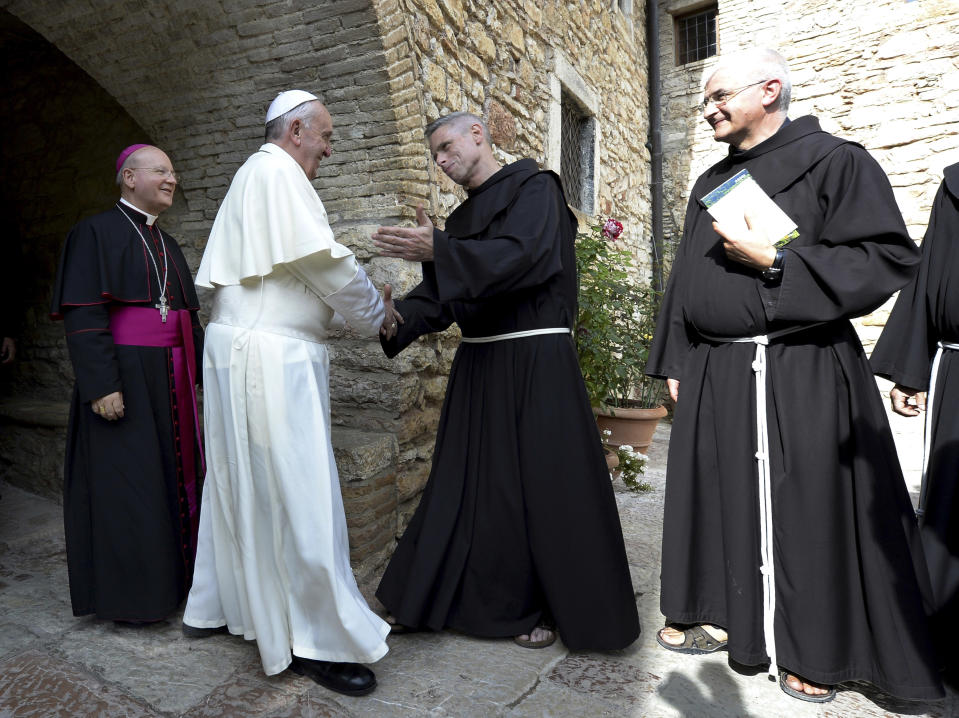 FILE -- In this photo taken on Oct. 4, 2013, Pope Francis is welcomed by friars during his visit of the Eremo delle Carceri hermitage, near Assisi, Italy. If there ever was an indication that the Jesuit from Argentina would be a very different kind of pope it was in his decision to name himself after St. Francis of Assisi, the 13th century friar who gave up his wealth to minister to the poor. (AP Photo/Andreas Solaro, pool)