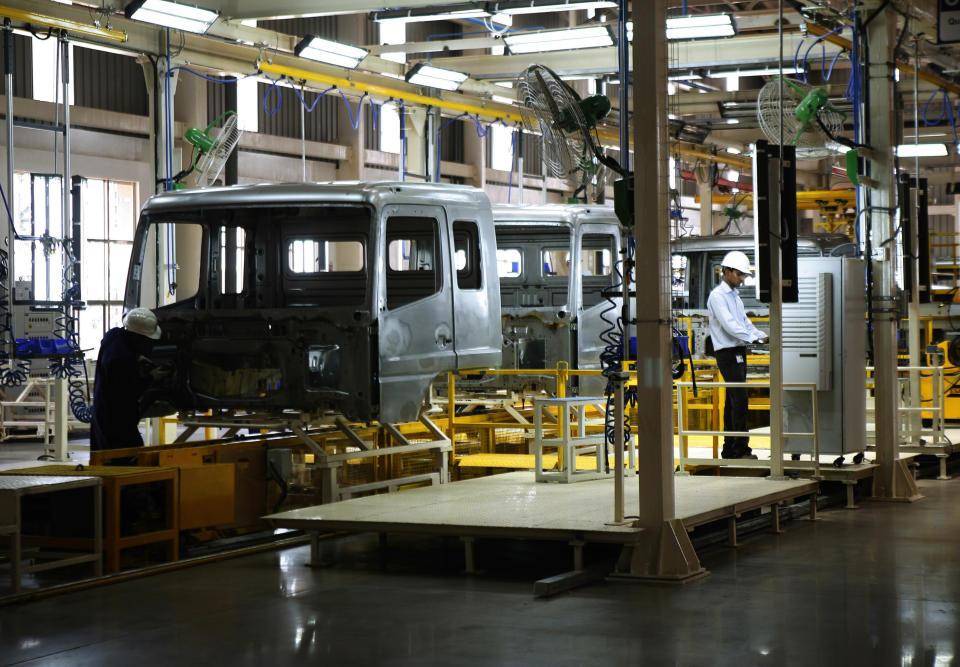 A Daimler AG worker stands near an assembly line during the opening ceremony of Daimler's new factory in Oragadam at Kancheepuram district 60 kilometers (38 miles) from Chennai, India, Wednesday, April 18, 2012. The German auto maker will start building trucks at the new factory beginning in the third quarter. The factory will initially have a capacity to make 36,000 trucks a year and raise it to 72,000 units, the company said. (AP Photo/Arun Shankar)