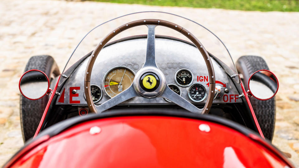 A view of the steering wheel and dash of a 1954 Ferrari Tipo 625 Monoposto race car.
