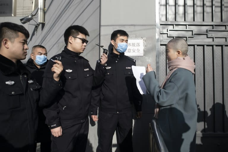 Police outside the Hongsecun People's High Court in south Beijing block the entrance as Li Wenzu attempts to submit to a a petition protesting her husband's indefinite detention