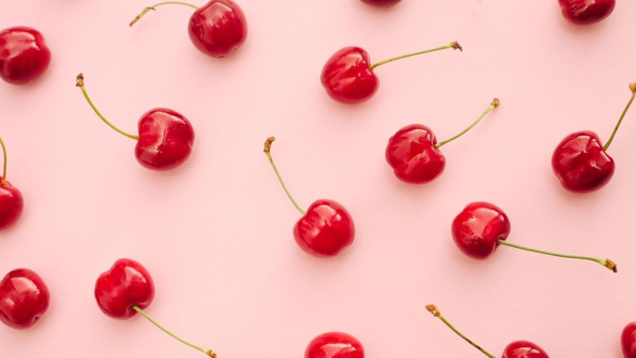 red cherry summer fruits over pink background