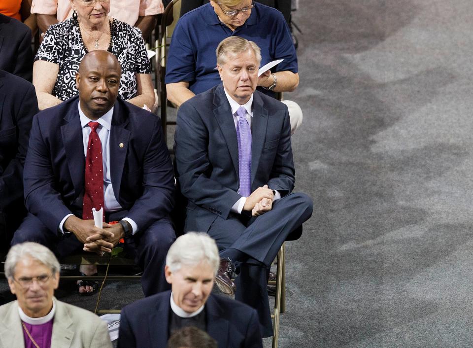 Sens. Lindsey Graham, R-S.C., and Tim Scott, R-S.C., attend a memorial service for the victims of the shooting at Emanuel AME Church on June 19, 2015, in Charleston, S.C.