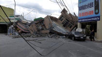This photo provided by Hualien County fire department show a collapsed residential building following earthquake in Yuli township in Hualien County, eastern Taiwan, Sunday, Sept. 18, 2022. A 7-11 convenience store was at the first floor of the collapse building. A strong earthquake shook much of Taiwan on Sunday, toppling at least one building and trapping two people inside and knocking part of a passenger train off its tracks at a station.(Hualien County Fire Department via AP)