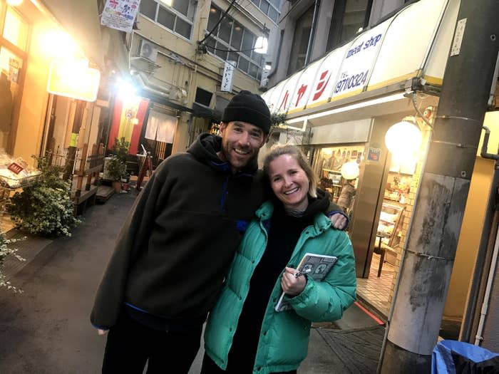 Two people smiling on a street