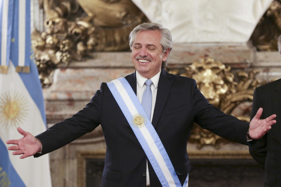 Argentina's President Alberto Fernandez opens his arms at the presidential palace in Buenos Aires, Argentina, Tuesday, Dec. 10, 2019. Fernandez became president of Argentina on Tuesday, returning the country's Peronist political movement to power amid an economic crisis and rising poverty. (AP Photo/Daniel Jayo)