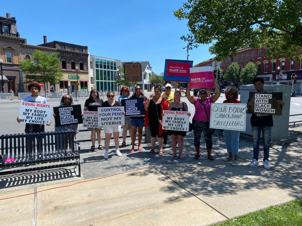 Protesters hold signs at a Day of Action rally on Taunton Green, Sunday, July 10, 2022, protesting the overturning of Roe v. Wade.