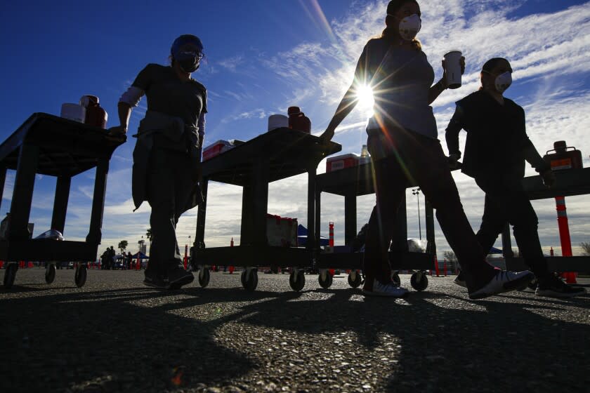 Fontana, CA - February 02: Healthcare workers on the way to their stations at "super site" COVID-19, Moderna mRNA-1273 vaccination event established for a day by San Bernardino County health at Auto Club Speedway on Tuesday, Feb. 2, 2021 in Fontana, CA.(Irfan Khan / Los Angeles Times)