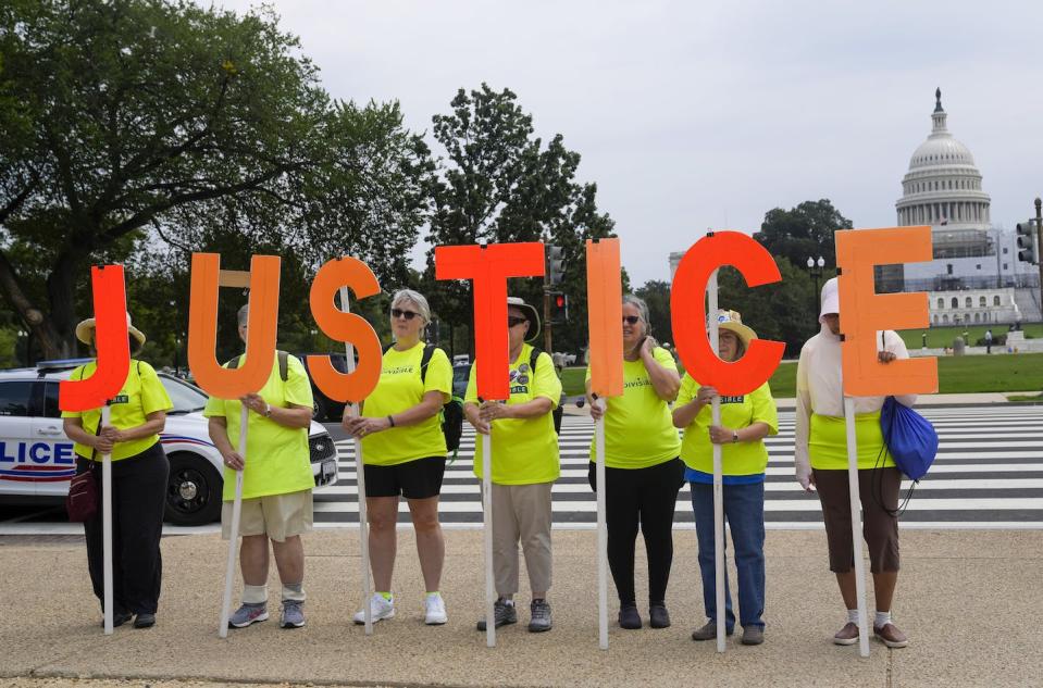 Anti-Donald Trump protesters hold letters that spell out ‘justice’ in Washington, D.C., on Aug. 3 as former president Donald Trump was set to appear in federal court on charges that he sought to overturn the results of the 2020 presidential election. (AP Photo/Jess Rapfogel)