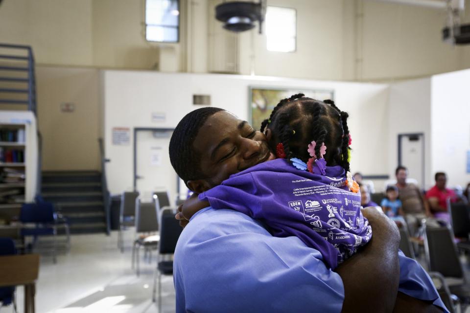 Tylan Gregory hugs his daughter during a "Get On the Bus" visiting day to Folsom State Prison