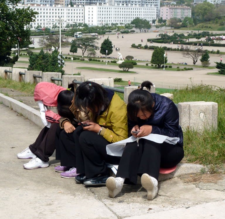 Girls use mobile phones in a park in Pyongyang on September 22, 2010. Mobile phones were introduced in 2008 through a joint venture with the Egyptian telecom firm Orascom, and a domestic Intranet was launched in 2002