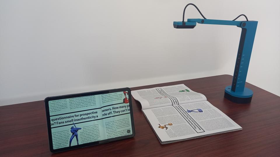 Ipevo VZ-X document camera on desk scanning book and the image appearing on a tablet