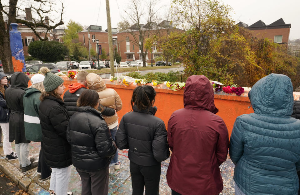 Mourners look over flowers that line a bridge near the scene of a shooting on the grounds of the University of Virginia Tuesday Nov. 15, 2022, in Charlottesville. Va. Authorities say three people have been killed and two others were wounded in a shooting at the University of Virginia and a student suspect is in custody. (AP Photo/Steve Helber)