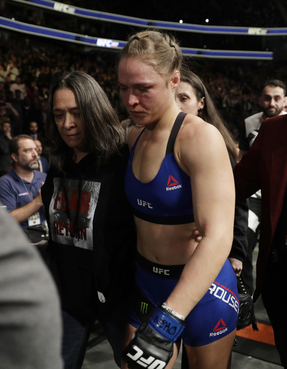 Ronda Rousey leaves the octagon after losing to Amanda Nunes in the first round of their women's bantamweight championship mixed martial arts bout at UFC 207, Friday, Dec. 30, 2016, in Las Vegas. Nunes won the fight after it was stopped in the first round. (AP Photo/John Locher)