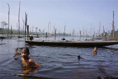 Children swim in an artificial reservoir created for the Nam Theun 2 dam in Khammouane province October 28, 2013. REUTERS/Aubrey Belford