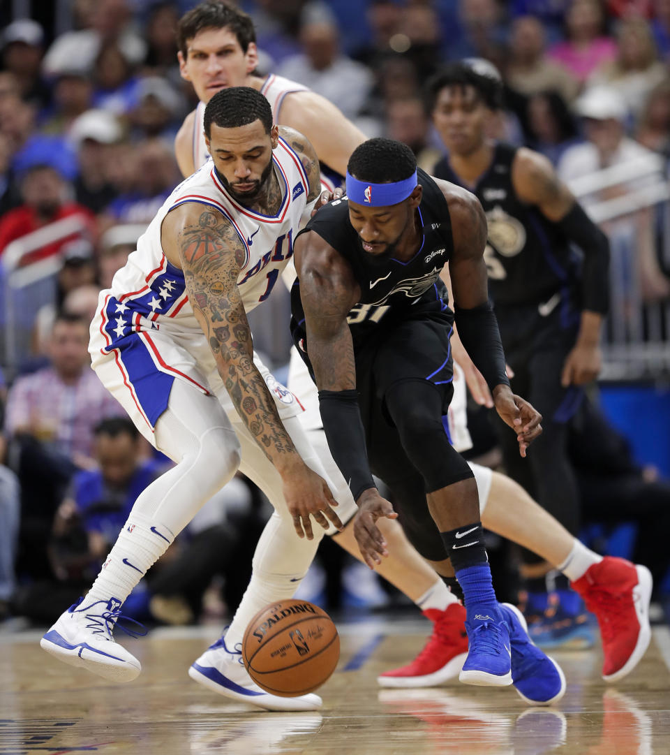 Philadelphia 76ers' Mike Scott, left, and Orlando Magic's Terrence Ross go after the ball during the first half of an NBA basketball game, Monday, March 25, 2019, in Orlando, Fla. (AP Photo/John Raoux)