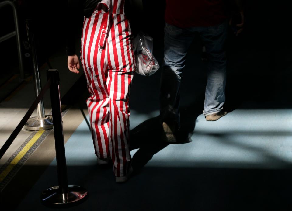 A Wisconsin fan wearing the iconic candy-striped overalls walks through Hinkle Fieldhouse for the Badgers' game against Baylor during the second round of the 2021 NCAA Division I basketball tournament in Indianapolis, Indiana, on Sunday, March 21, 2021.