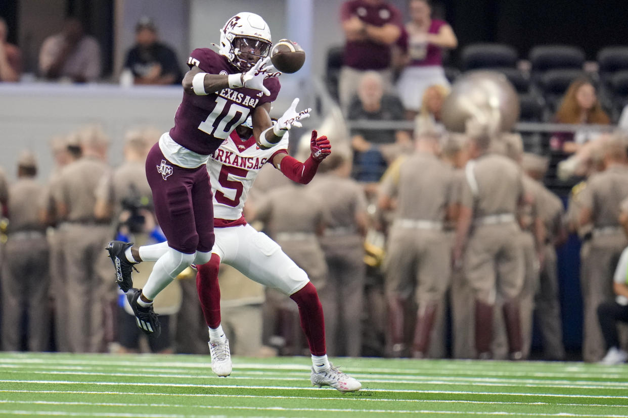 Texas A&M defensive back Dezz Ricks (10) intercepts a pass intended for Arkansas wide receiver Tyrone Broden (5) during the first half of an NCAA college football game, Saturday, Sept. 28, 2024, in Arlington, Texas. (AP Photo/Julio Cortez)