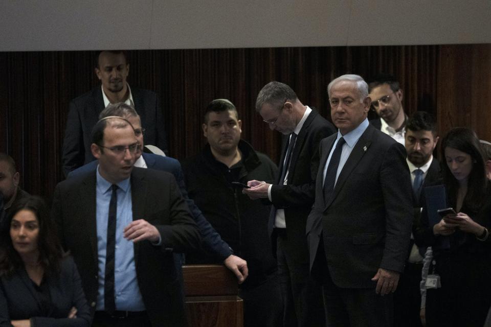 Israeli Prime Minister Benjamin Netanyahu, right, stands on the floor of the country’s parliament as people mass outside to protest his government’s judicial overhaul plan, March 27, 2023. <a href="https://newsroom.ap.org/detail/Israel%20Politics/0f3aa28151a3467eaa0e6ba21fdfad5a?Query=Israel%20&mediaType=photo&sortBy=arrivaldatetime:desc&dateRange=now-24h&totalCount=127&currentItemNo=16" rel="nofollow noopener" target="_blank" data-ylk="slk:AP Photo/ Maya Alleruzzo;elm:context_link;itc:0;sec:content-canvas" class="link ">AP Photo/ Maya Alleruzzo</a>