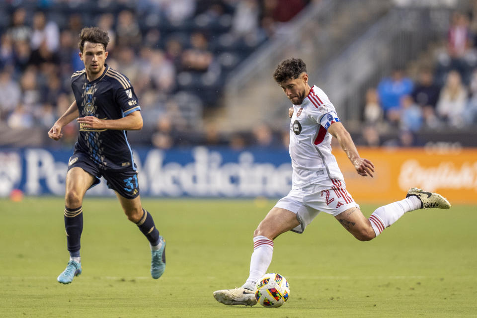 Toronto FC's Jonathan Osorio, right, kicks the ball as Philadelphia Union's Leon Flach watches during the first half of an MLS soccer match Wednesday, May 29, 2024, in Chester, Pa. (AP Photo/Chris Szagola)