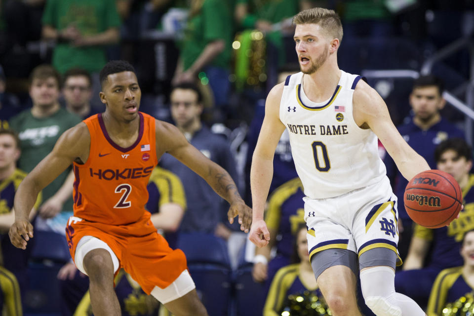 Notre Dame's Rex Pflueger (0) looks to pass around Virginia Tech's Landers Nolley II (2) during the first half of an NCAA college basketball game Saturday, March 7, 2020, in South Bend, Ind. (AP Photo/Robert Franklin)