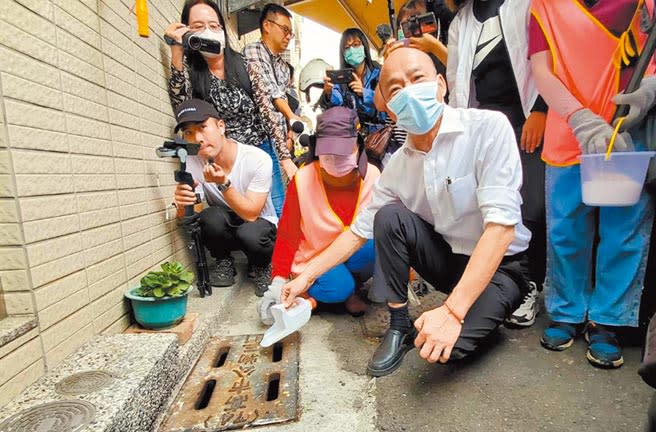 高雄市長韓國瑜4日再度到三民區獅湖公園及周邊巷弄視察，並捲起袖子、蹲下倒粗鹽到水溝杜絕孳生源。 （劉宥廷攝）