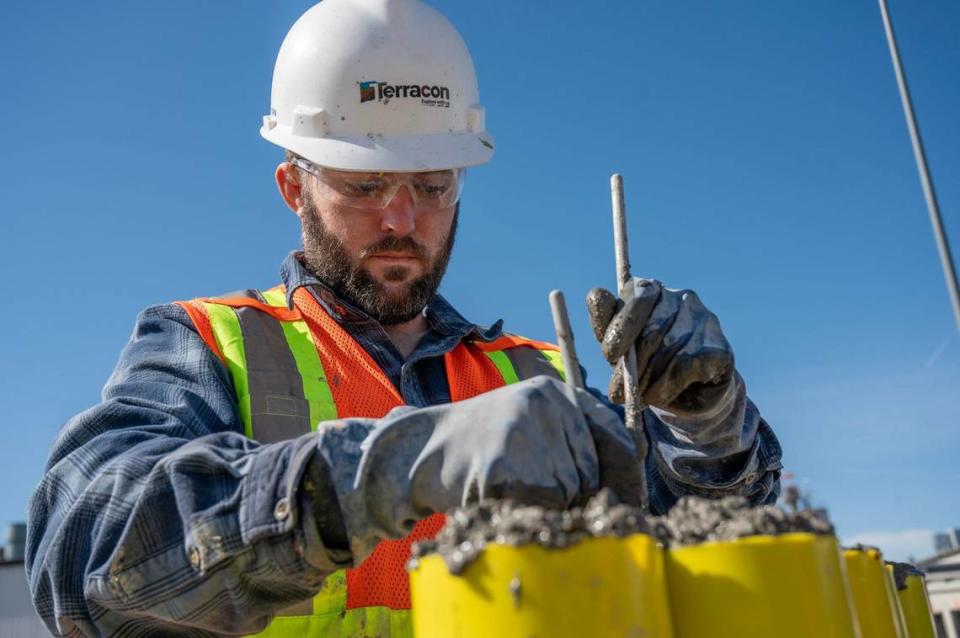 Jordan Orr, of Terracon Consultants Inc., mixes concrete into cylinders as part of the levee project at an Armourdale construction site. Emily Curiel/ecuriel@kcstar.com