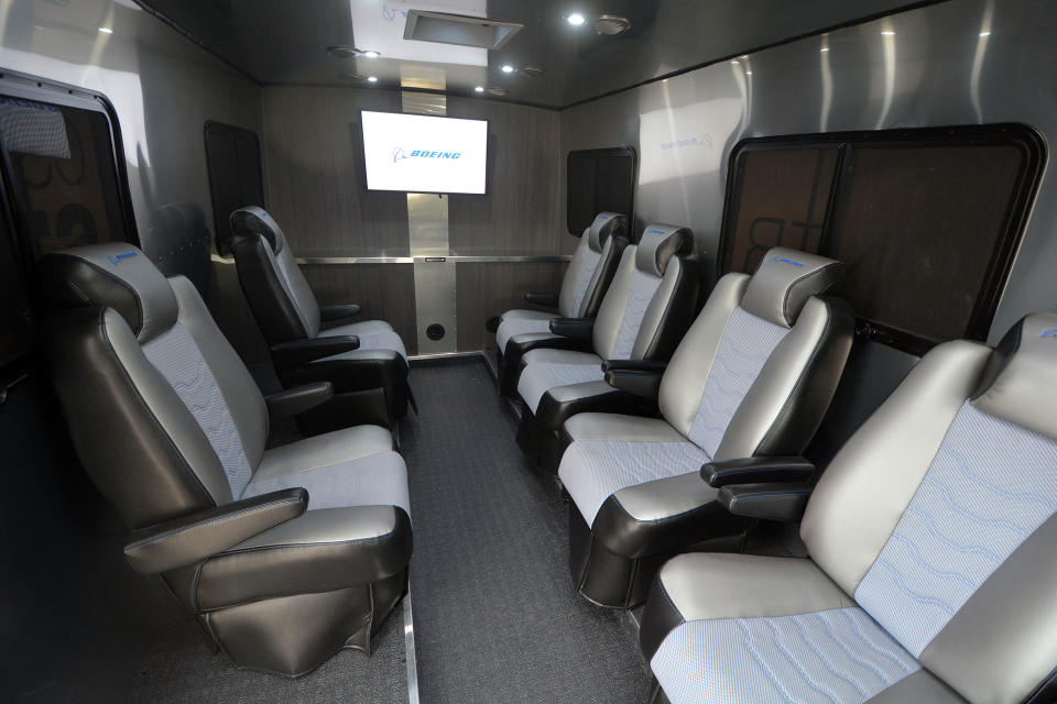 interior photo looking toward the back of a large gray van, showing six bucket seats