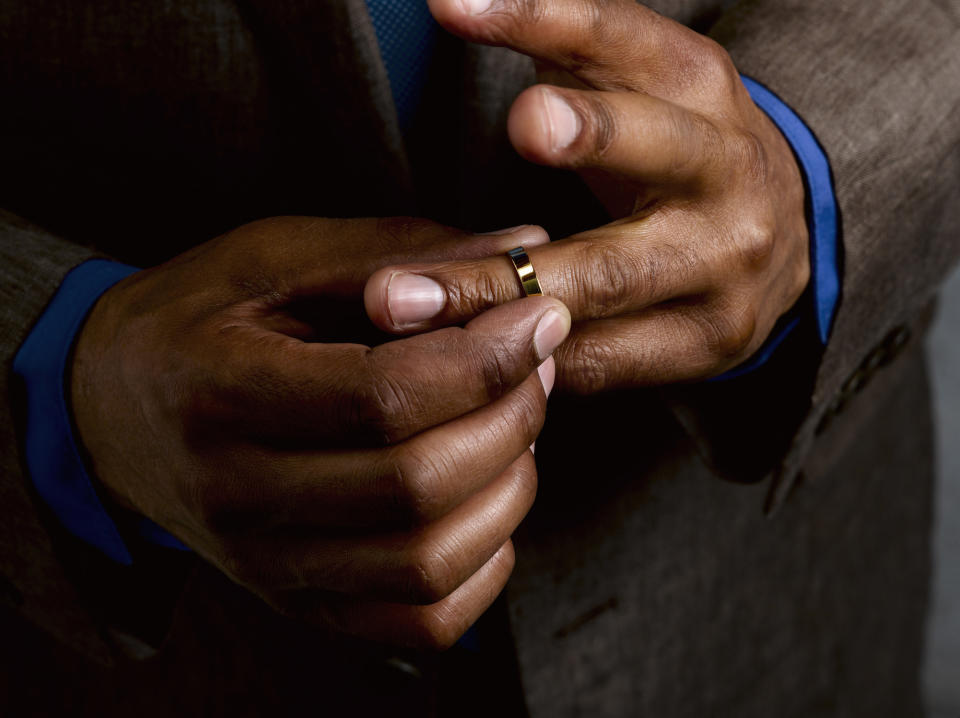 Close-up of a person's hands fidgeting with a wedding ring