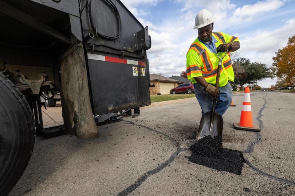 Pothole crew member Vernon Sawyer works to fill a pothole in the street at a neighborhood in Fort Worth on Thursday, Dec. 7, 2023.