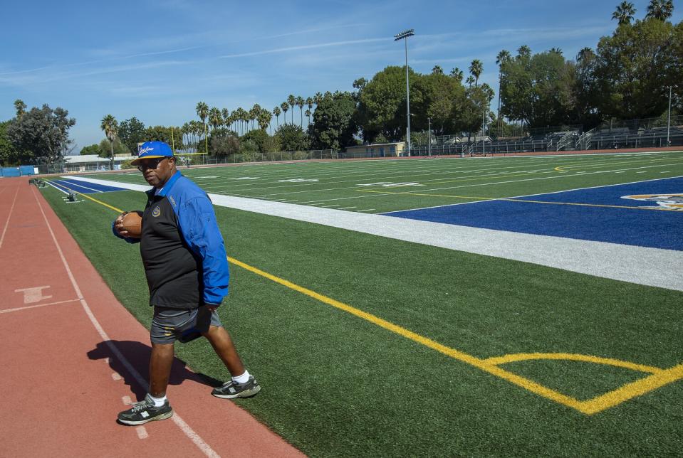 Crenshaw coach Robert Garrett strides off the football field on campus.